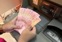stock-photo-sidoarjo-indonesia-february-a-hand-show-money-from-an-atm-cash-withdrawal-2425550949-transformed
